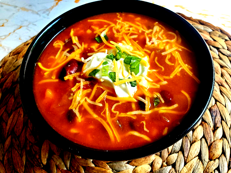 pumpkin chili topped with sour cream, green onion, and cheese