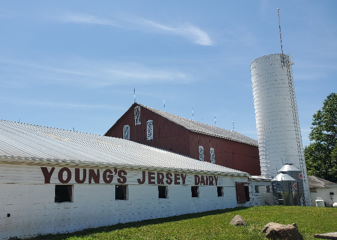 a red and white barn with a silo