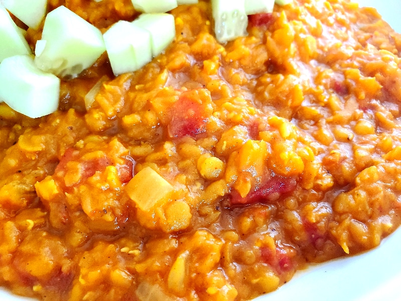 Creamy red lentils served over rice topped with diced cucumber