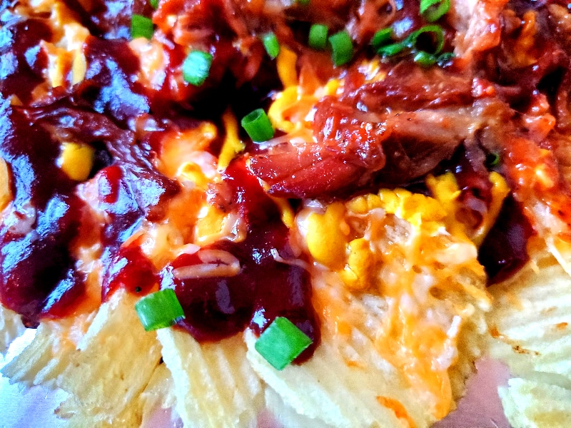 Salty potato chips topped with sweet BBQ sauce, mustard, cheese, and pulled pork make Austin-Style BBQ Nachos the new greatest appetizer!