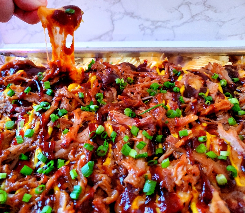 Salty potato chips topped with sweet BBQ sauce, mustard, cheese, and pulled pork make Austin-Style BBQ Nachos the new greatest appetizer!