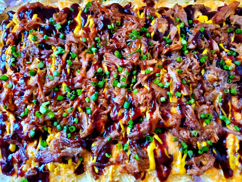 Salty potato chips topped with sweet BBQ sauce, mustard, cheese, and pulled pork make Austin-Style BBQ Nachos the new greatest appetizer!