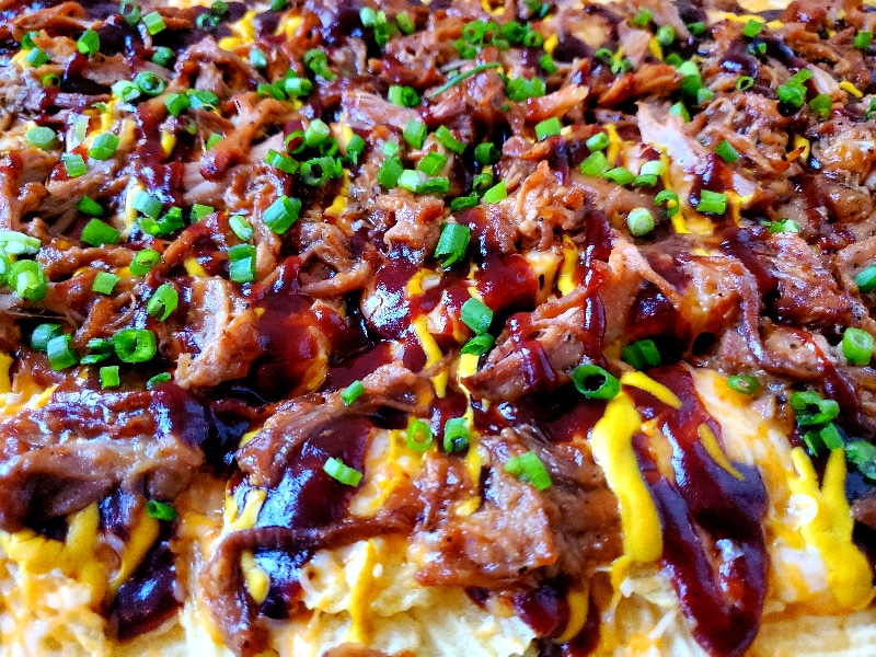 Salty potato chips topped with sweet BBQ sauce, mustard, cheese, and pulled pork make Austin-Style BBQ Nachos the new greatest appetizer!