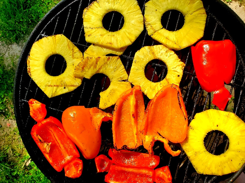 pineapple and peppers cooking on a grill