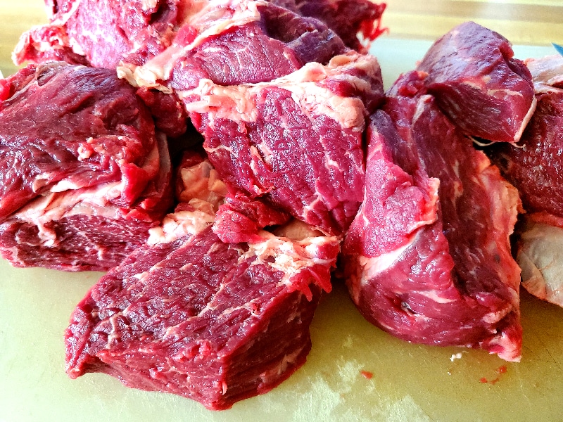 Grass-fed beef cut into chunks on plate