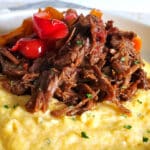 Mexican Shredded Beef on top of Cheese Grits with sauteed peppers and onions